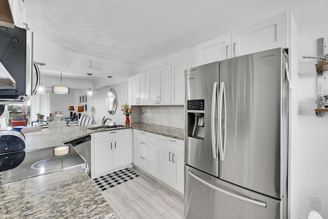 kitchen with sink, white cabinets, kitchen peninsula, and appliances with stainless steel finishes