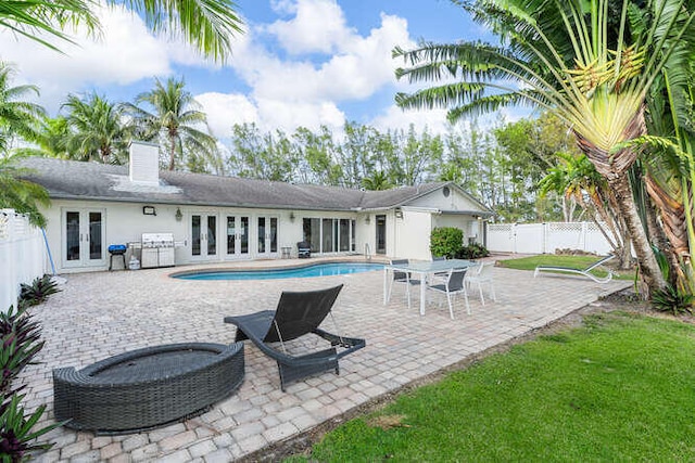 exterior space with a fenced in pool and french doors