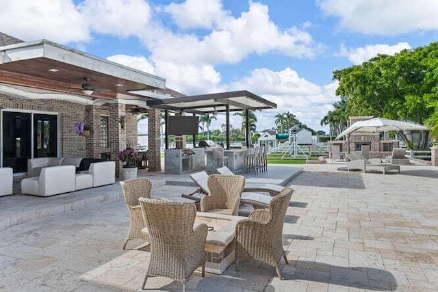 view of patio / terrace with a bar, ceiling fan, and an outdoor hangout area