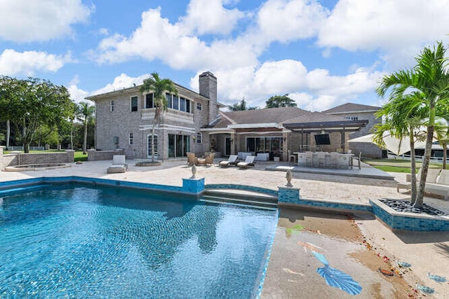 view of swimming pool featuring a bar and a patio