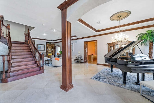 interior space with crown molding, ornate columns, a tray ceiling, and a notable chandelier