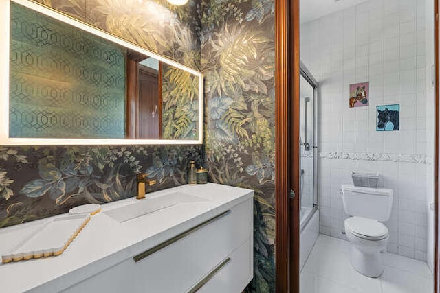 bathroom with vanity, tile walls, tile patterned floors, and toilet