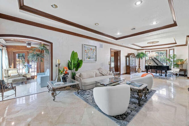 living room featuring an inviting chandelier, crown molding, and a raised ceiling