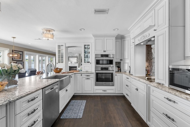 kitchen with white cabinetry, sink, light stone counters, stainless steel appliances, and crown molding