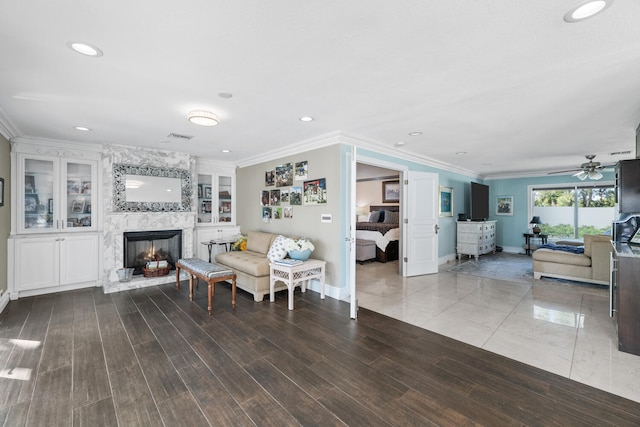 living room with crown molding, hardwood / wood-style floors, a fireplace, and built in shelves