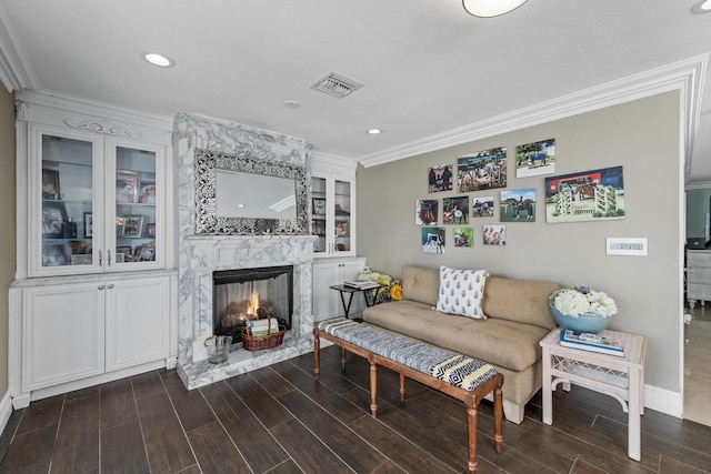 living room featuring crown molding and a high end fireplace