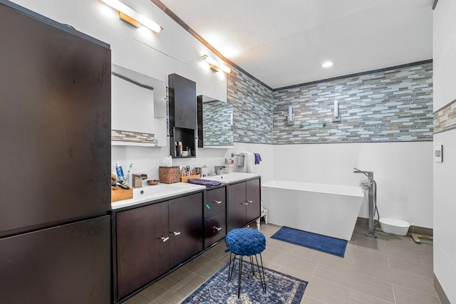 bathroom with vanity, tile walls, a tub, and a textured ceiling