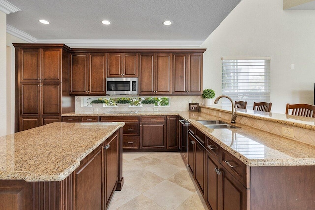 kitchen with light stone countertops, crown molding, backsplash, a kitchen breakfast bar, and sink