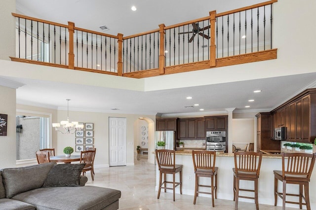 living room featuring ceiling fan with notable chandelier and ornamental molding