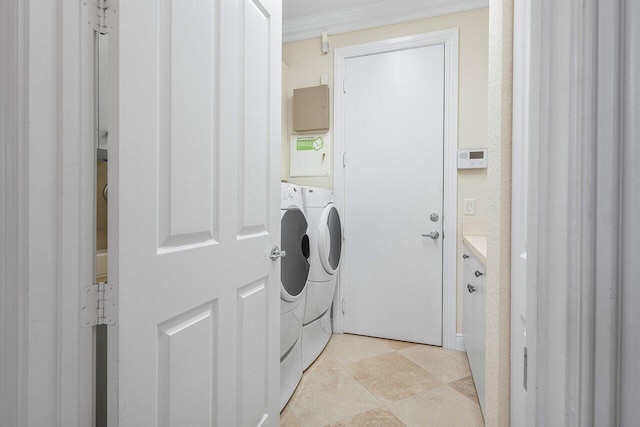 clothes washing area with crown molding and washing machine and clothes dryer