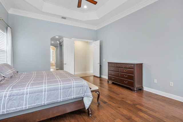 bedroom featuring ceiling fan, crown molding, a raised ceiling, and dark hardwood / wood-style floors