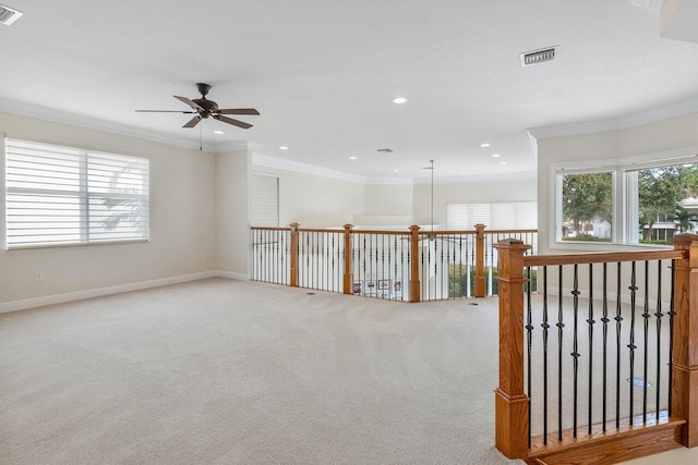 carpeted spare room with ceiling fan and crown molding