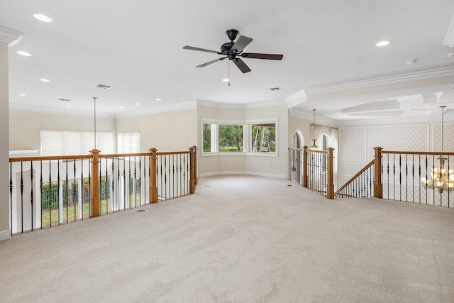 empty room featuring ceiling fan with notable chandelier, light carpet, and crown molding