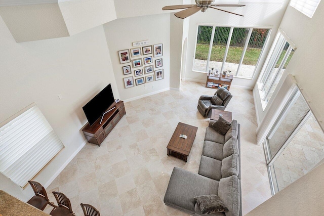 living room with ceiling fan and high vaulted ceiling