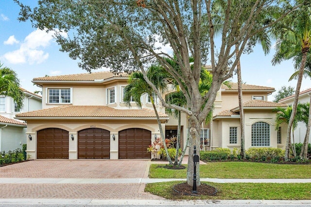 mediterranean / spanish home featuring a front lawn and a garage