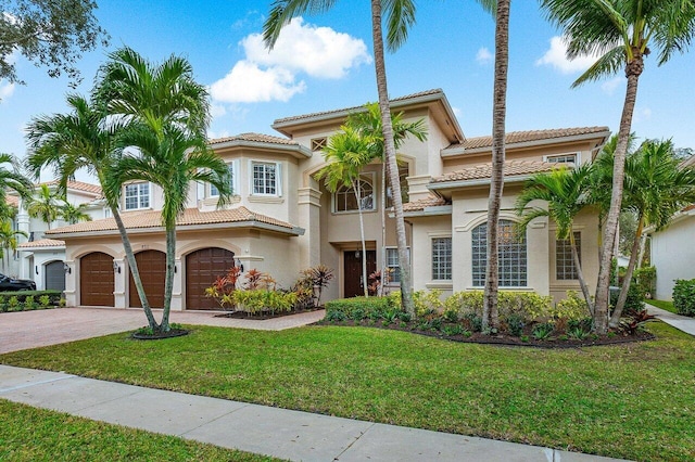 mediterranean / spanish-style home featuring a front yard and a garage