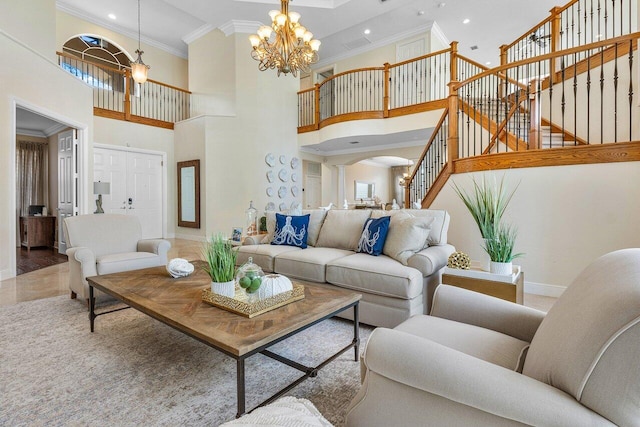 living room featuring a high ceiling, ornamental molding, and a notable chandelier