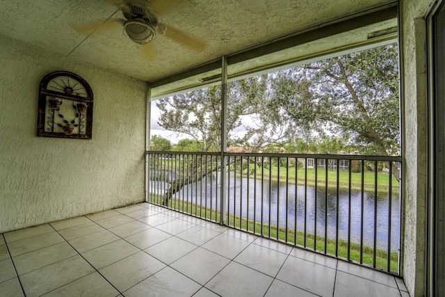 unfurnished sunroom with a water view, ceiling fan, and a wealth of natural light