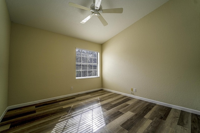 spare room featuring ceiling fan, dark hardwood / wood-style flooring, and vaulted ceiling