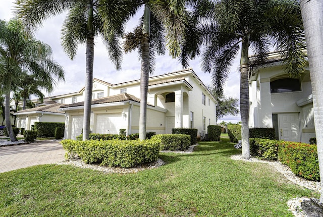 mediterranean / spanish-style home featuring a garage and a front yard