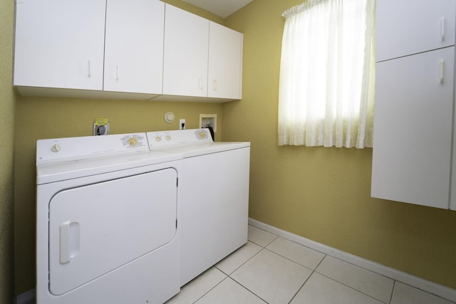 laundry area with cabinets, washing machine and clothes dryer, and light tile patterned floors