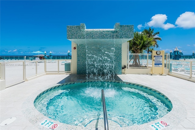 view of pool with a hot tub