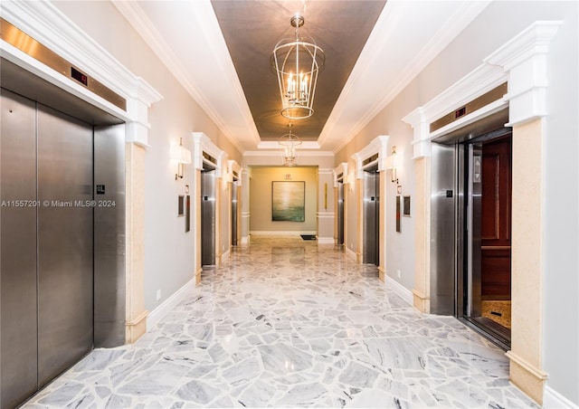 corridor with ornamental molding, elevator, a raised ceiling, and a notable chandelier