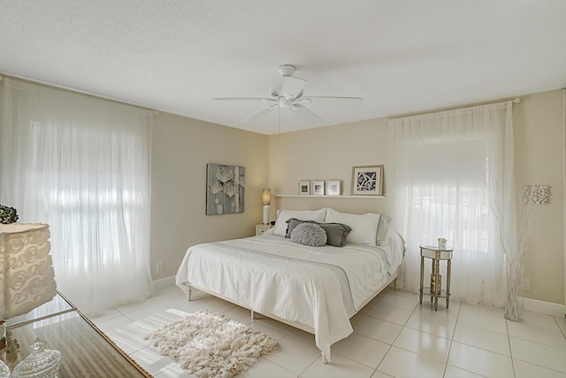 tiled bedroom featuring ceiling fan and a textured ceiling