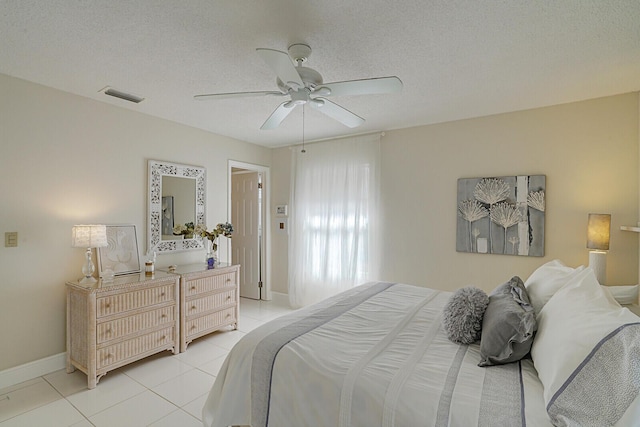 bedroom featuring ceiling fan, a textured ceiling, and light tile patterned floors