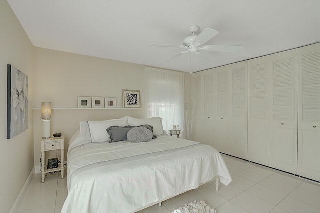 bedroom with ceiling fan, light tile patterned floors, and a closet