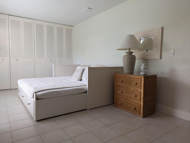 tiled bedroom featuring a textured ceiling and a closet