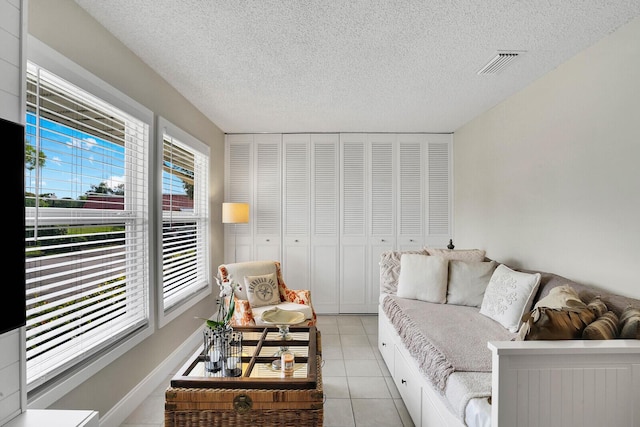 living room featuring a textured ceiling and light tile patterned floors