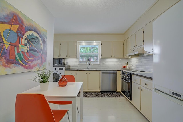 kitchen with washer / dryer, black appliances, decorative backsplash, sink, and cream cabinetry