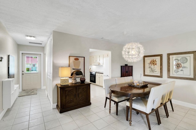 tiled dining space featuring a textured ceiling