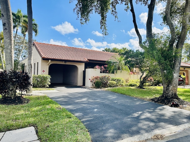 mediterranean / spanish house featuring a garage and a front lawn