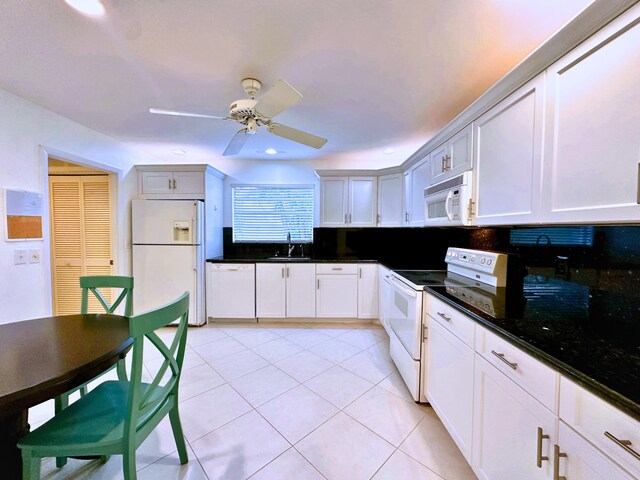 kitchen featuring tasteful backsplash, sink, white appliances, white cabinetry, and light tile patterned floors