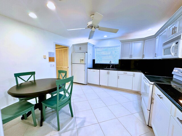 kitchen with white appliances, white cabinetry, sink, ceiling fan, and light tile patterned floors