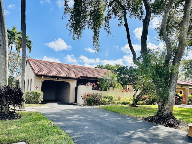 mediterranean / spanish house featuring a garage and a front lawn