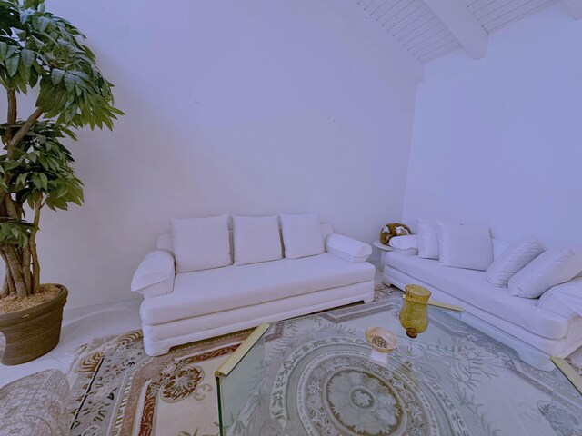 tiled living room featuring ceiling fan, plenty of natural light, and floor to ceiling windows