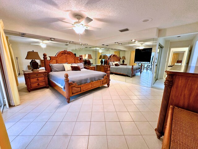 tiled bedroom featuring ceiling fan, a textured ceiling, and access to outside