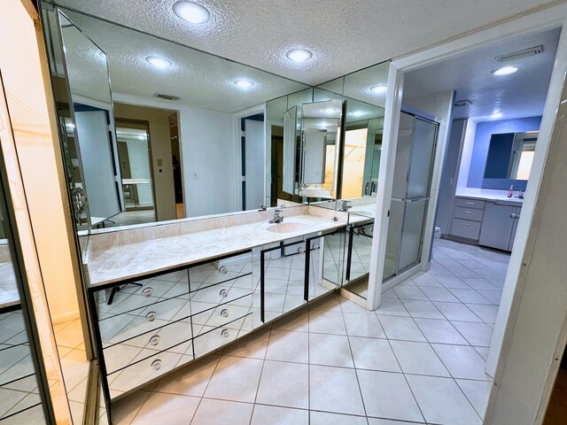 bathroom with a textured ceiling, tile patterned floors, and vanity