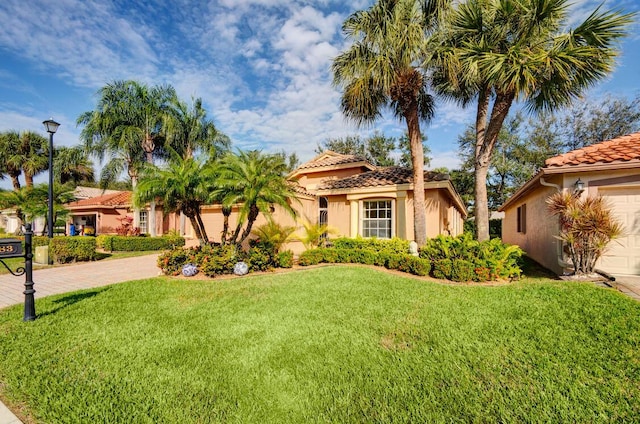 mediterranean / spanish-style house featuring a front lawn and a garage