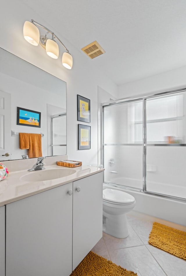 full bathroom featuring tile patterned flooring, vanity, shower / bath combination with glass door, and toilet