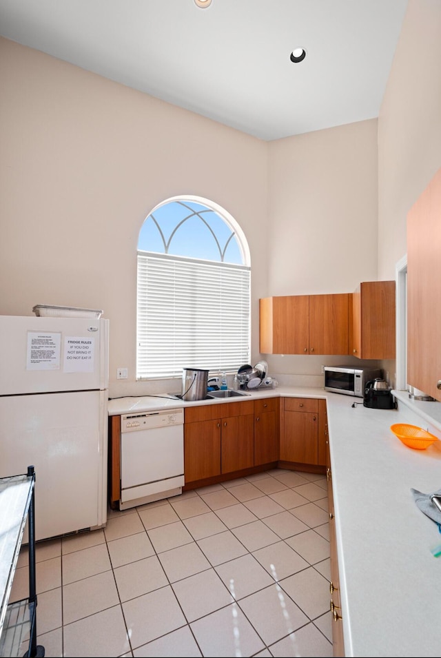 kitchen with white appliances, sink, and light tile patterned floors