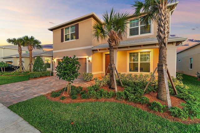 10312 SW Green Turtle Ln, Port Saint Lucie, FL 34987 - view of front of home featuring a garage, stucco siding, decorative driveway, and a lawn