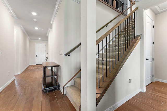 staircase featuring crown molding and hardwood / wood-style floors