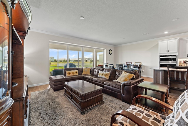 living room with a textured ceiling, ornamental molding, and light wood-type flooring