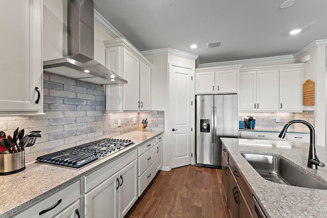 kitchen featuring exhaust hood, appliances with stainless steel finishes, decorative backsplash, and sink