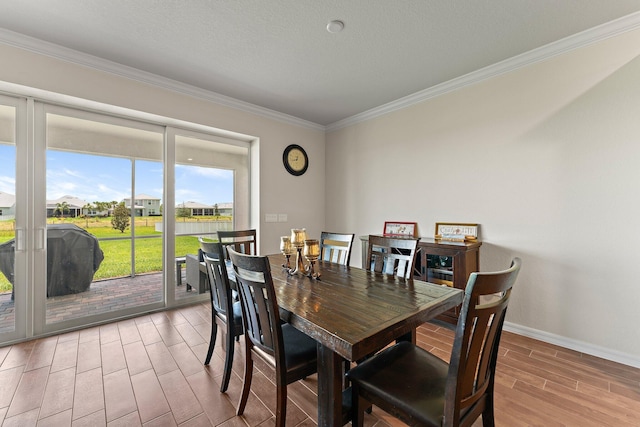 dining space featuring ornamental molding and light wood-type flooring