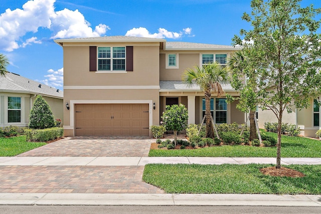 10312 SW Green Turtle Ln, Port Saint Lucie, FL 34987 - view of front of home with stucco siding, an attached garage, decorative driveway, and a front yard